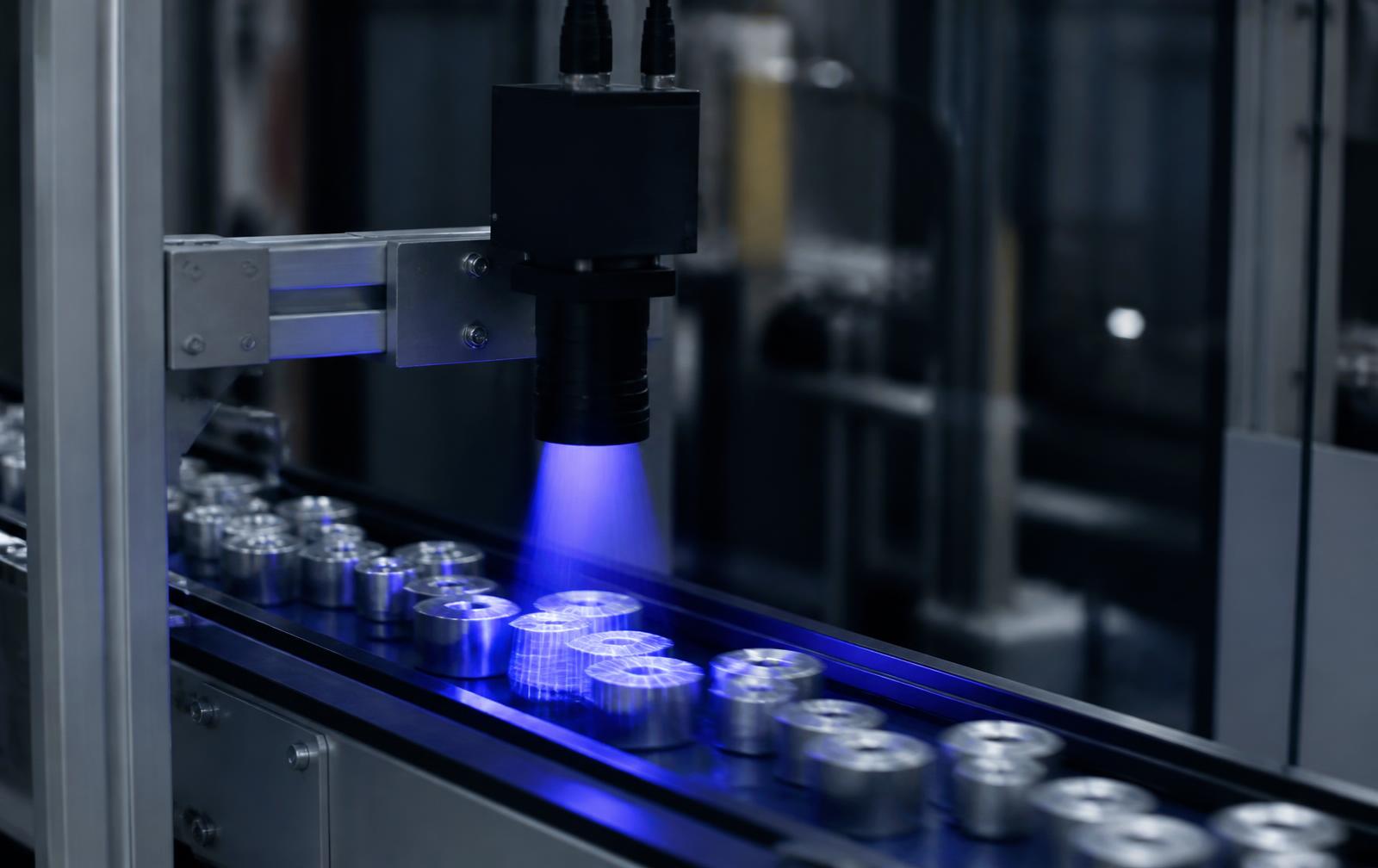 Machine vision camera inspecting metal parts on a moving conveyor